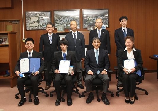 学長室にて記念撮影（前列左から，高橋さん，首藤さん，北野学長，佐藤さん　　　　　　　　　　　　　　　後列左から，工藤保健管理センター所長，今戸学長補佐，越智理事，中村学生支援部長）