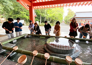 手水所で作法を教わる留学生たち