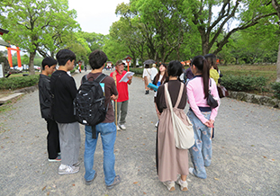 ガイドから宇佐神宮の歴史を学ぶ学生たち